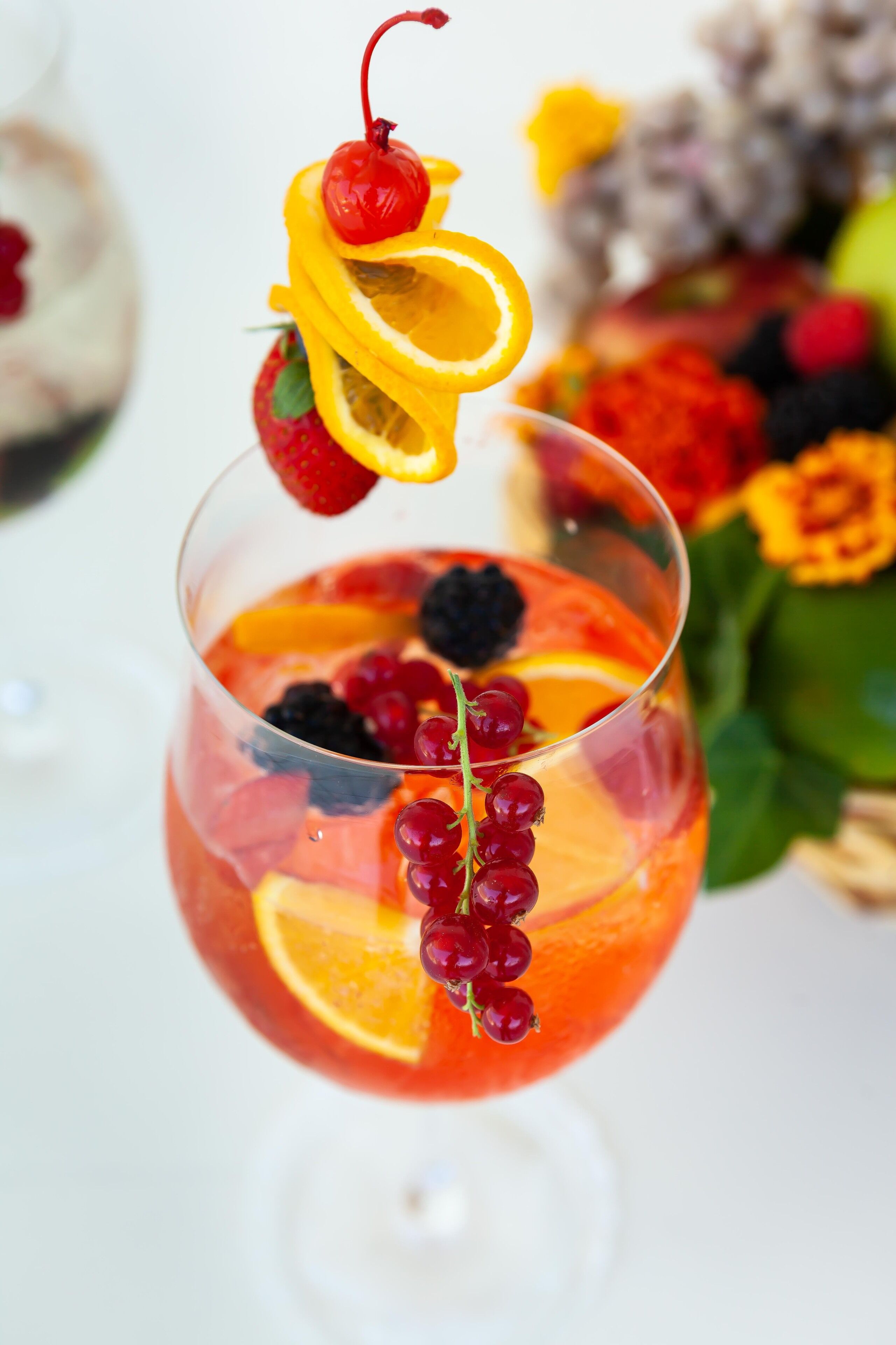 A cocktail with various fruits and a cherry garnish.