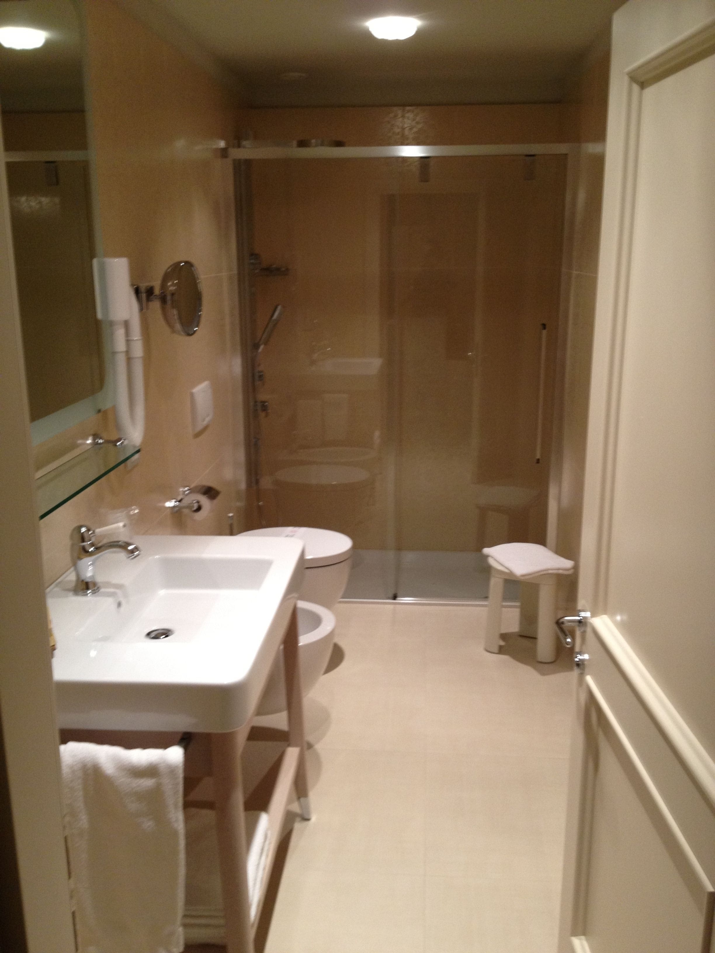A bathroom with a sink, toilet, and shower area.