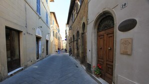 A narrow street with buildings on either side, including a building with a plaque that reads "Affittacamere Marlucia."