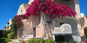 A building with a staircase, a balcony, and a satellite dish. - Bounganville PT (Budoni)