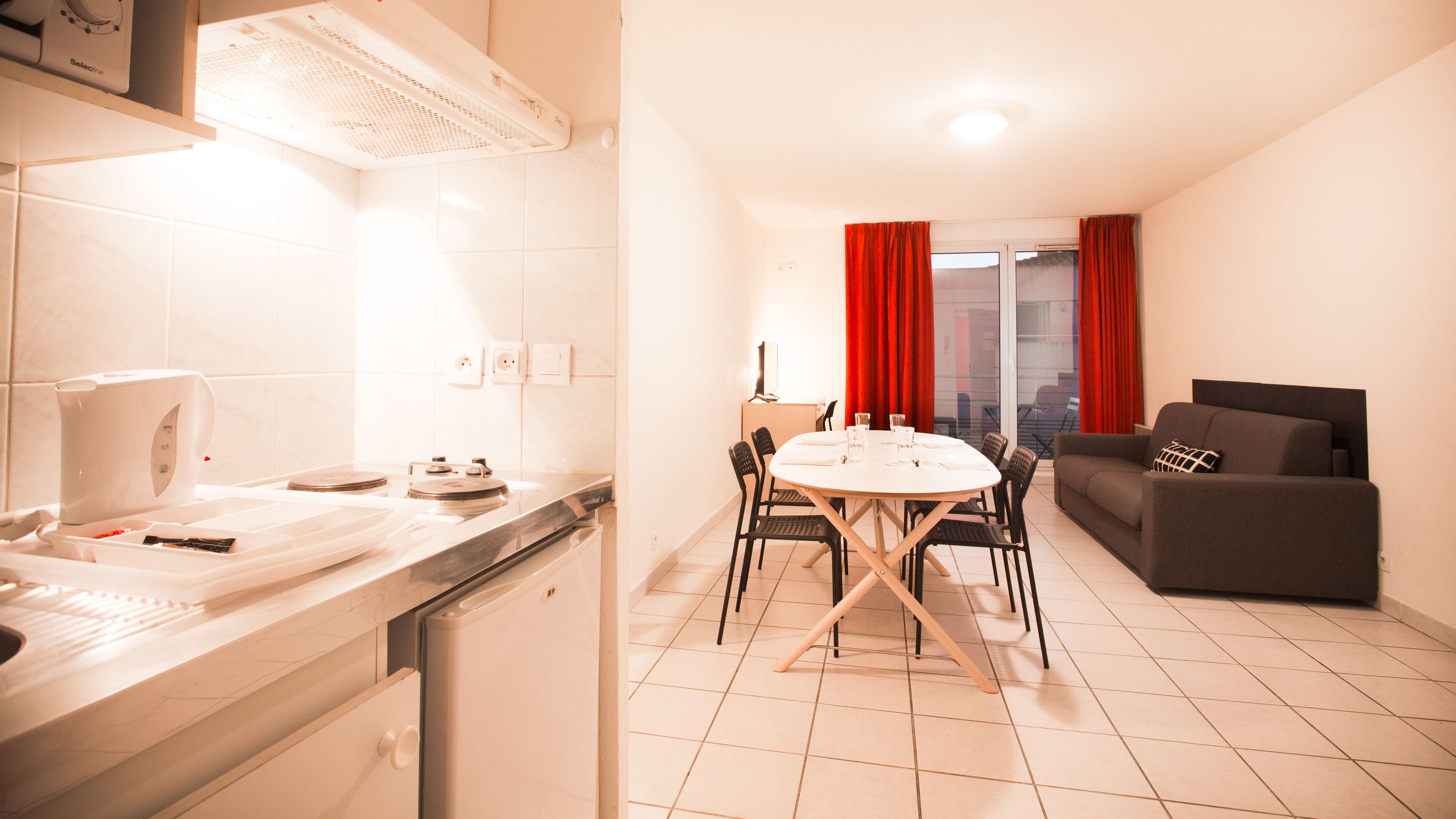 Una cocina moderna con comedor, sofá y vistas a través de un ventanal.