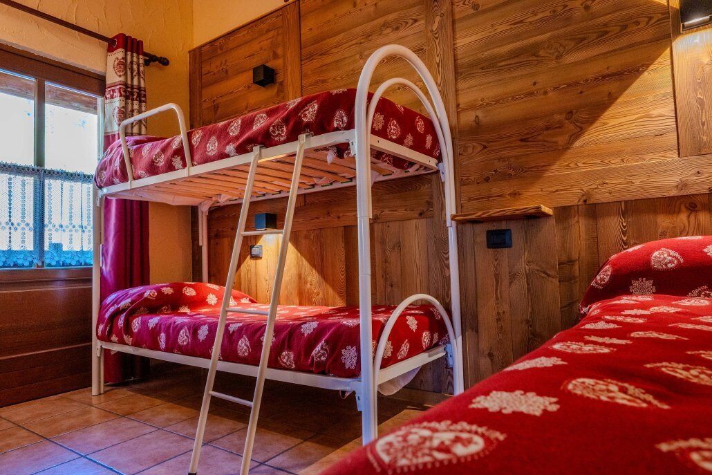 Una camera con un letto a castello e una finestra con tende.