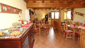 Una cocina acogedora con mobiliario de madera, un espacio tipo bufé y una persona al fondo.