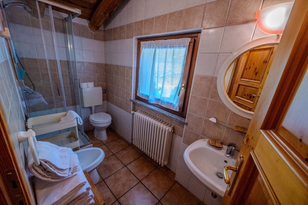 A compact bathroom with a shower, toilet, and sink.