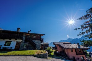 A traditional mountain village with stone buildings, a clear sky, and a view of distant mountains. - Residence Trompe-L'Oeil (Ayas)