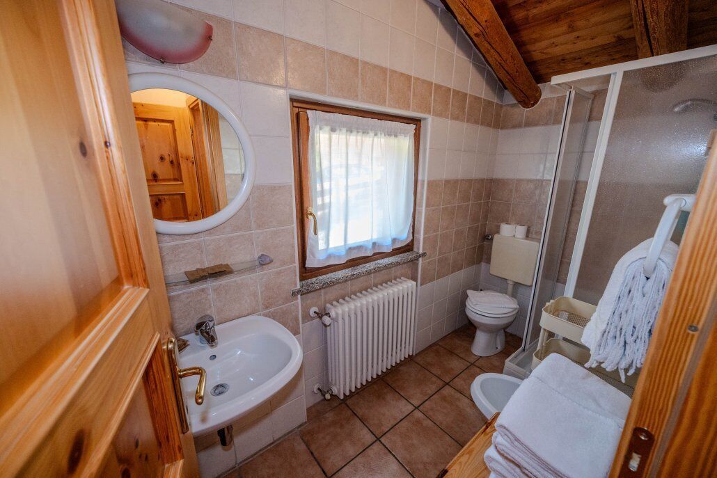 Un baño pequeño con lavamanos, inodoro y ducha.
