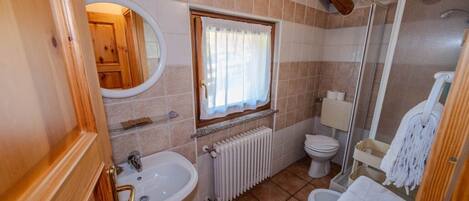 Un baño pequeño con lavamanos, inodoro y ducha.