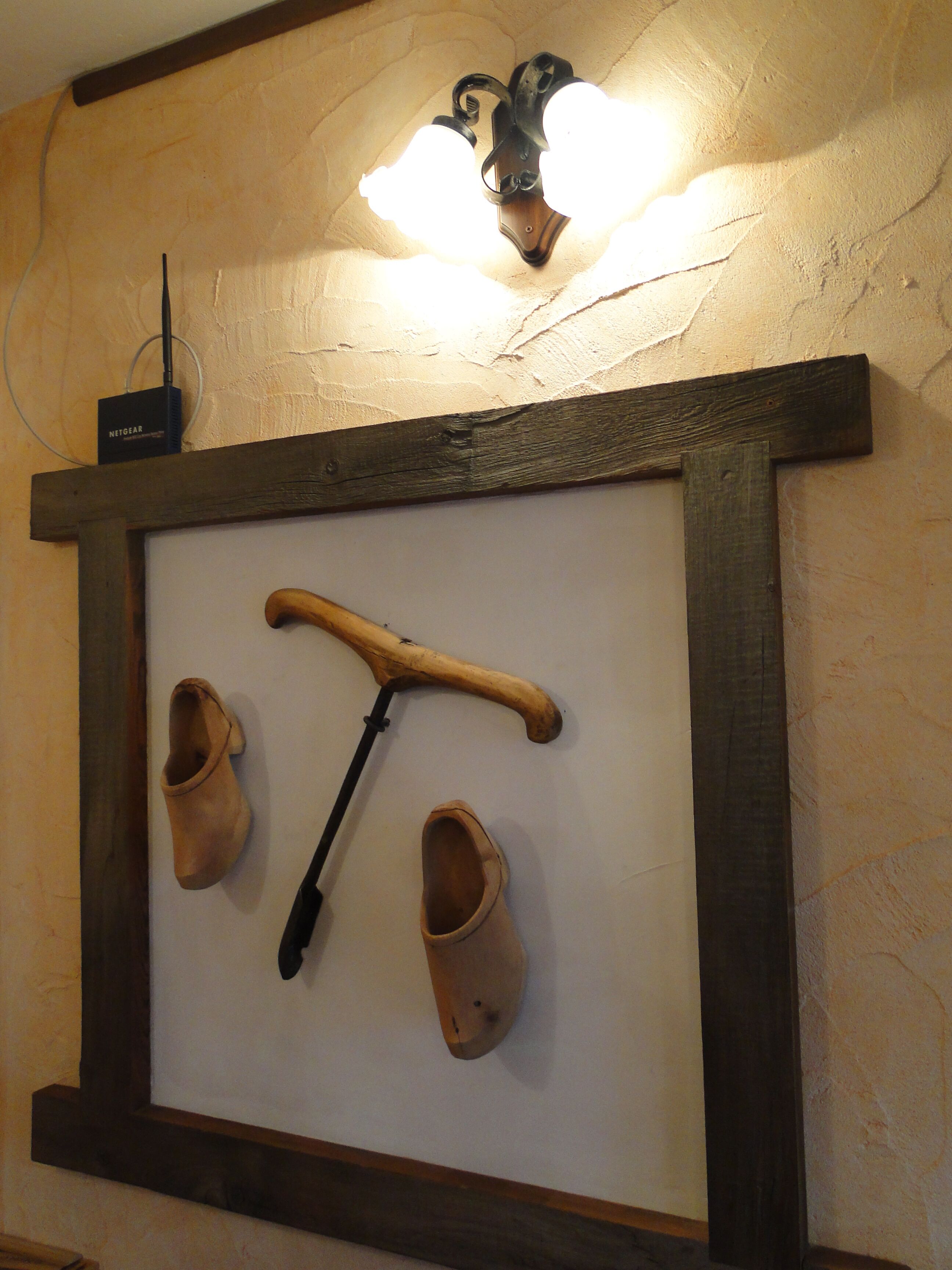 A wall-mounted clock with wooden elements and a rustic design.
