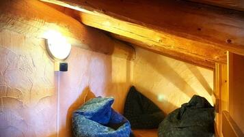 A cozy attic room with a sloped ceiling, a wall-mounted light, and two bean bags.