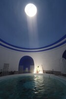 Piscina interna com teto alto e detalhes decorativos em azul.