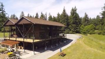 A two-story lodge with a covered deck and a large porch area.
