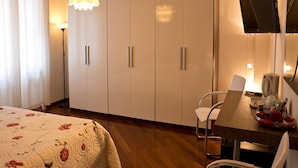 A hotel room with a bed, a desk with a chair, a television, and a wardrobe. - B&B Sul Corso (Salerno)