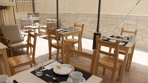 Un coin repas avec des meubles en bois et un mur en pierre.
