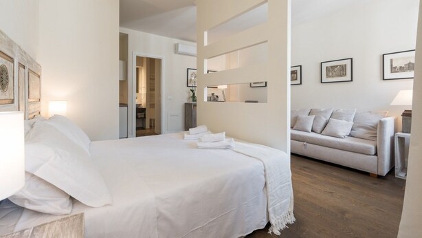 Une chambre d’hôtel avec un lit, un canapé et un mur orné de tableaux.