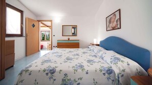 A bedroom with a bed, a dresser, a nightstand, a mirror, and a window. - The Muse (Massa Lubrense)