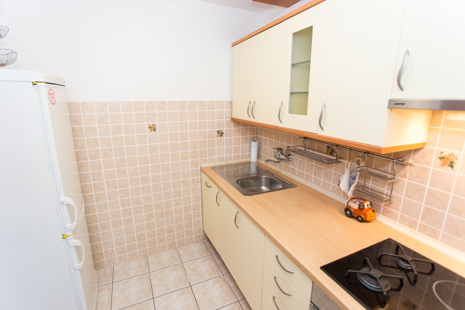 A compact kitchen with a sink, stove, and cabinets.