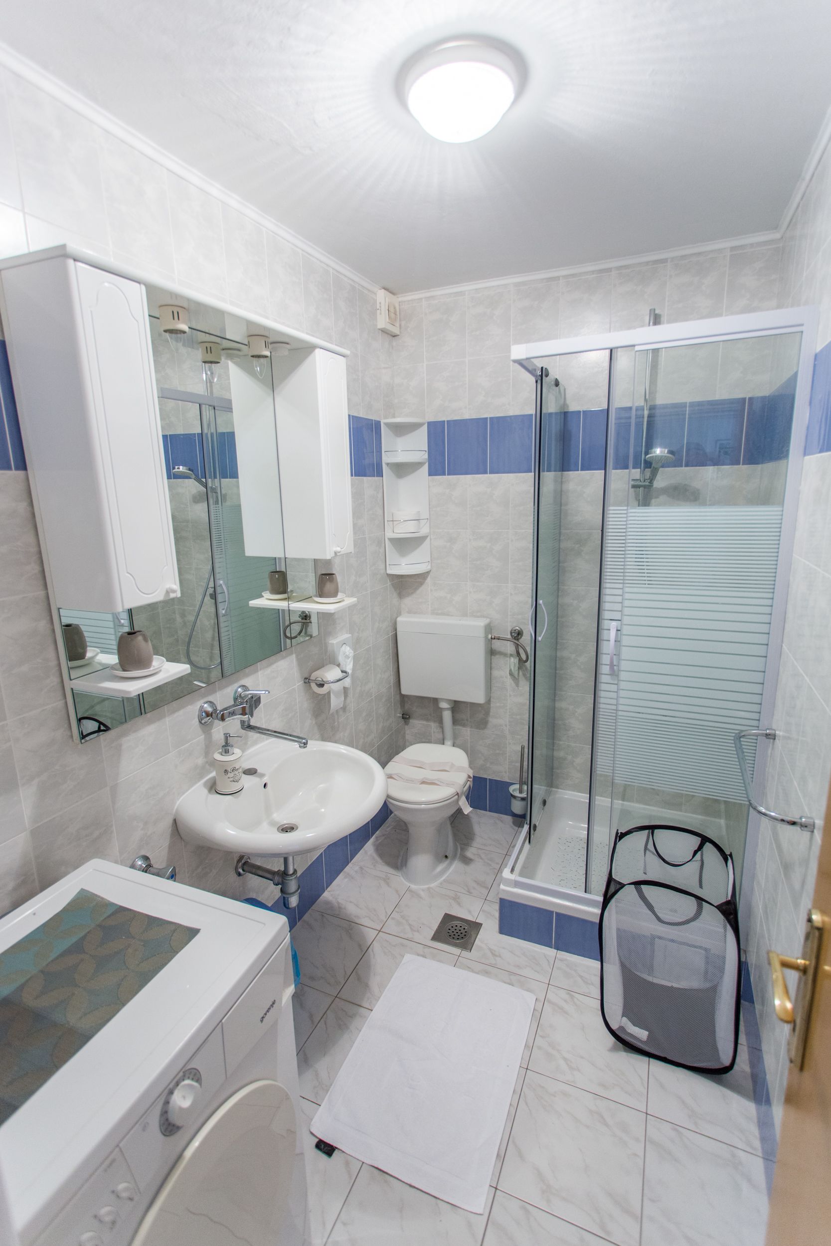A modern bathroom with a glass shower enclosure, a white sink, and a toilet.