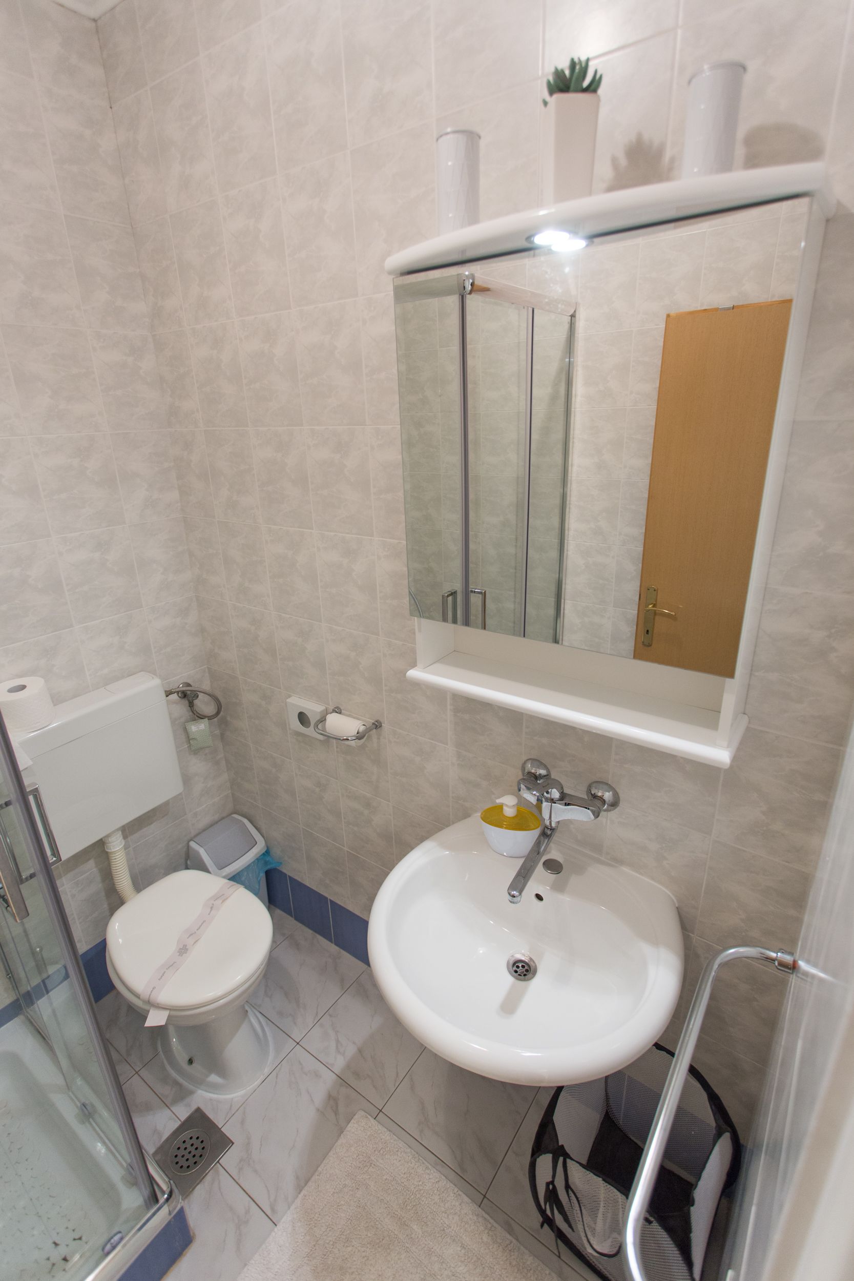 A bathroom with a toilet, sink, and shower.