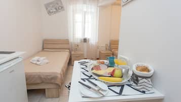 Un dormitorio pequeño y ordenado con una cama, una mesa preparada para el desayuno y una decoración de pared con temática de bicicletas.