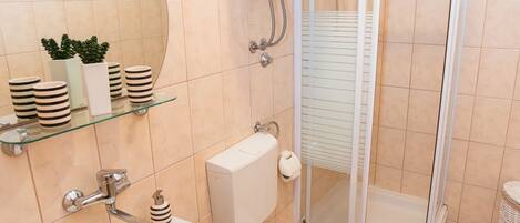 A bathroom with a sink, toilet, and shower.