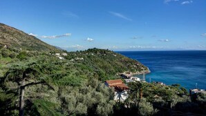 A coastal village with terraced houses, a clear view of the sea, and lush greenery. - Sunrise Suite (Massa Lubrense)