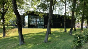 A modern building with a glass facade, surrounded by trees and grass. - Hostel Brønderslev (Bronderslev)