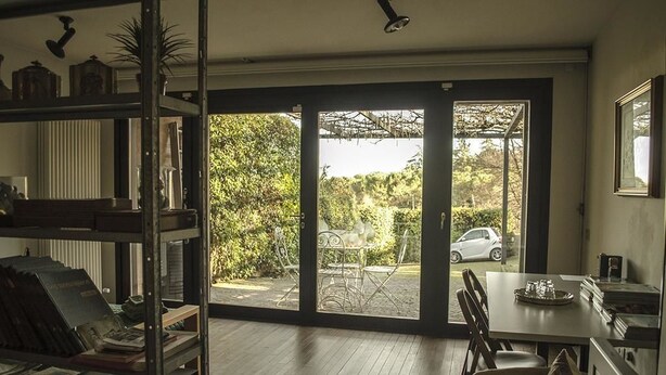 A room with a large sliding glass door leading to an outdoor patio area with a table and chairs. - Bed & Breakfast San Lazzaro Room (San Lazzaro di Savena)