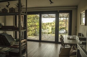 Ein Zimmer mit einer großen Schiebetür und Zugang zu einer Außenpatio mit Tisch und Stühlen.