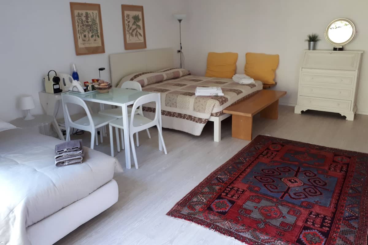 Une chambre à coucher comprenant un lit, un bureau, une chaise, une commode et un tapis.