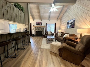 A modern living room with a fireplace, a bar area, and a seating arrangement.