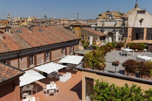 A rooftop terrace with outdoor seating and a view of the cityscape. - Harry's Bar Trevi Hotel & Restaurant (Rome)