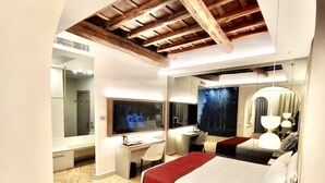 A modern hotel room with a large bed, a desk, a TV, and a mirror. - Harry's Bar Trevi Hotel & Restaurant (Rome)