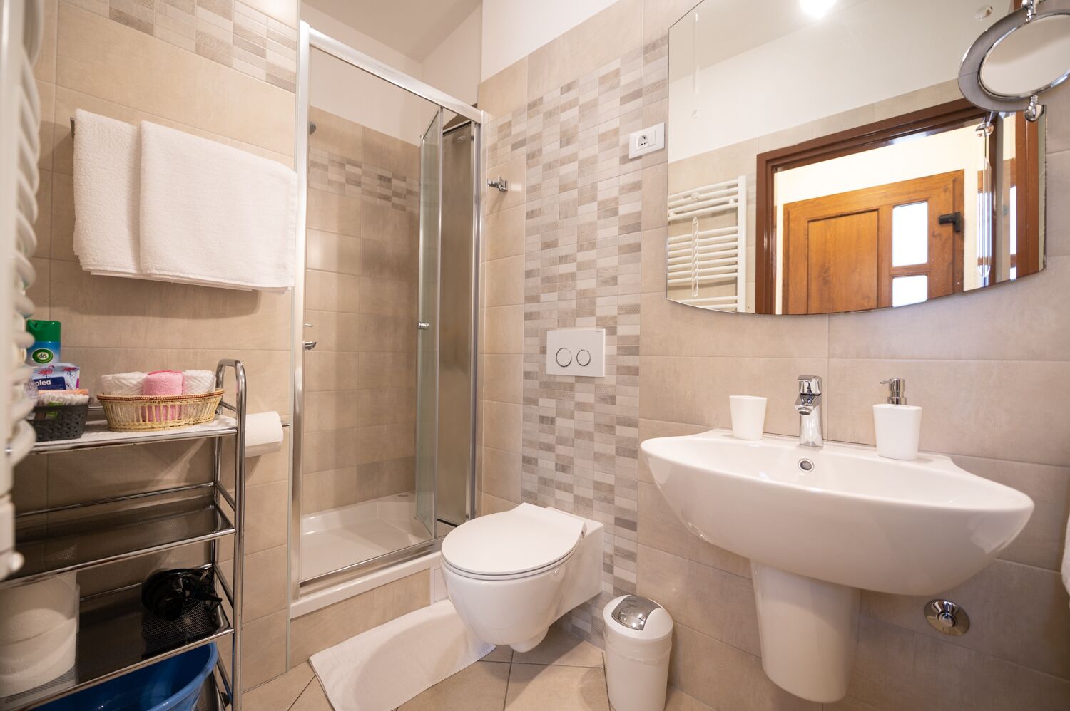 A modern bathroom with a glass shower, white sink, and toilet.