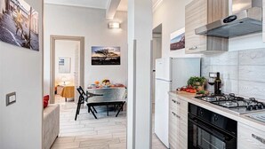 Eine moderne Küche mit Gasherd, Backofen und Essbereich mit Tisch für zwei Personen.
