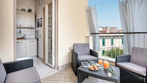 Un balcón con zona de comedor, cocina y vistas de la ciudad.