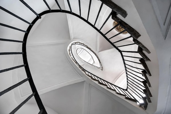 Una escalera de caracol con columna central y barandillas negras.