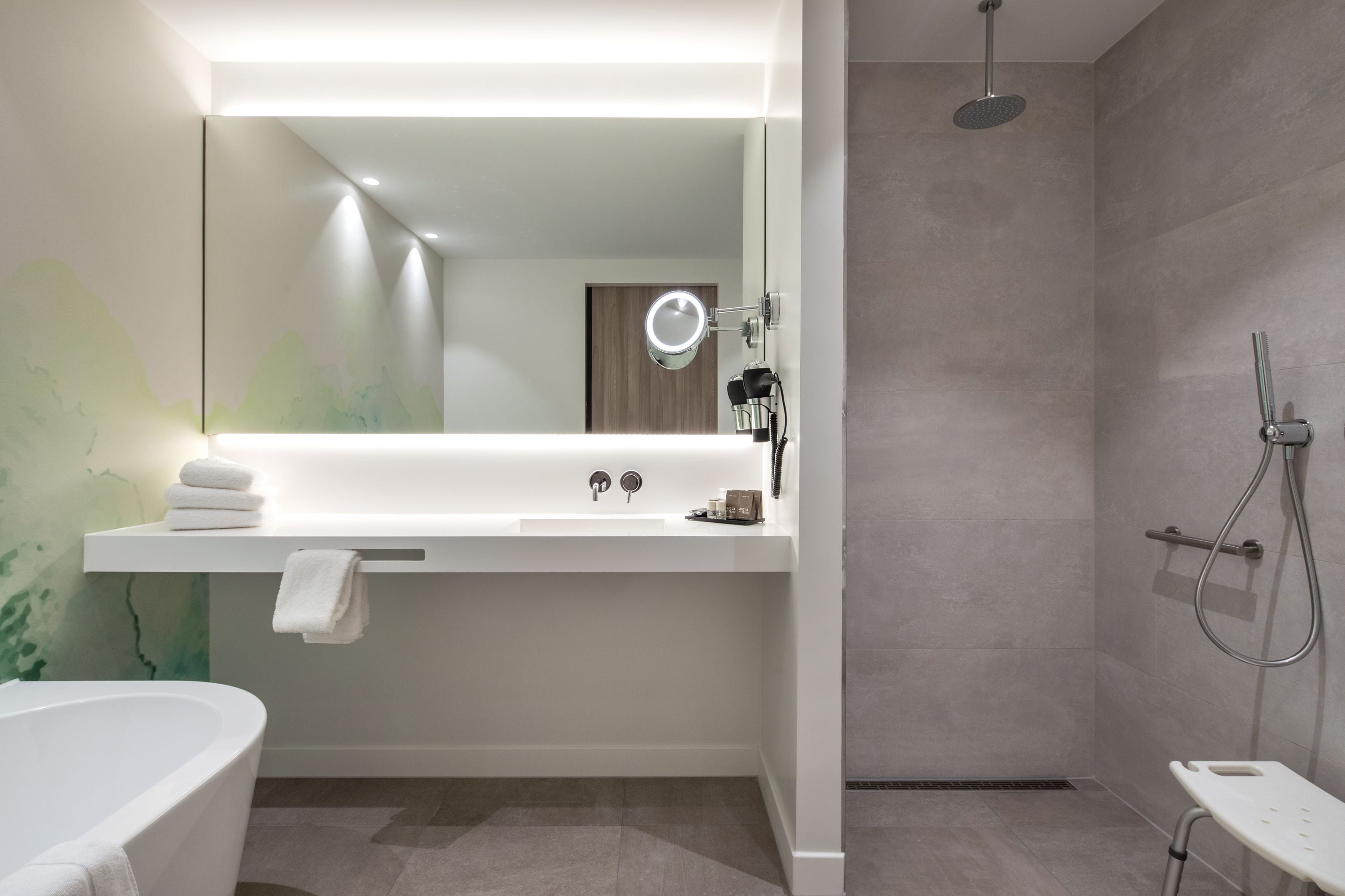 Een moderne badkamer met een badkuip, een wastafel met spiegel en een douche.