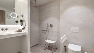 Un baño moderno con ducha, inodoro y lavamanos.