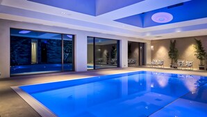 A modern indoor swimming pool with clear water, surrounded by large windows and indoor plants. - Van der Valk Hotel Tilburg (Tilburg)