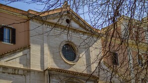 A building with a classical architectural style, featuring a prominent arched entrance and a circular window above it. - Santamaria Inn (Rome)