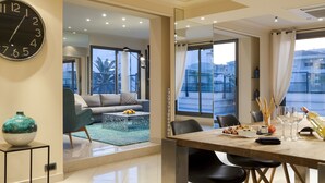 A modern dining area with a large table, chairs, and a view of the outside. - Nehô Suites Cannes Croisette (Cannes)