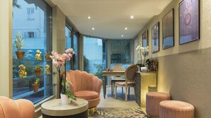 A modern interior with a seating area, a dining table, and large windows offering a view of the outside. - Nehô Suites Cannes Croisette (Cannes)