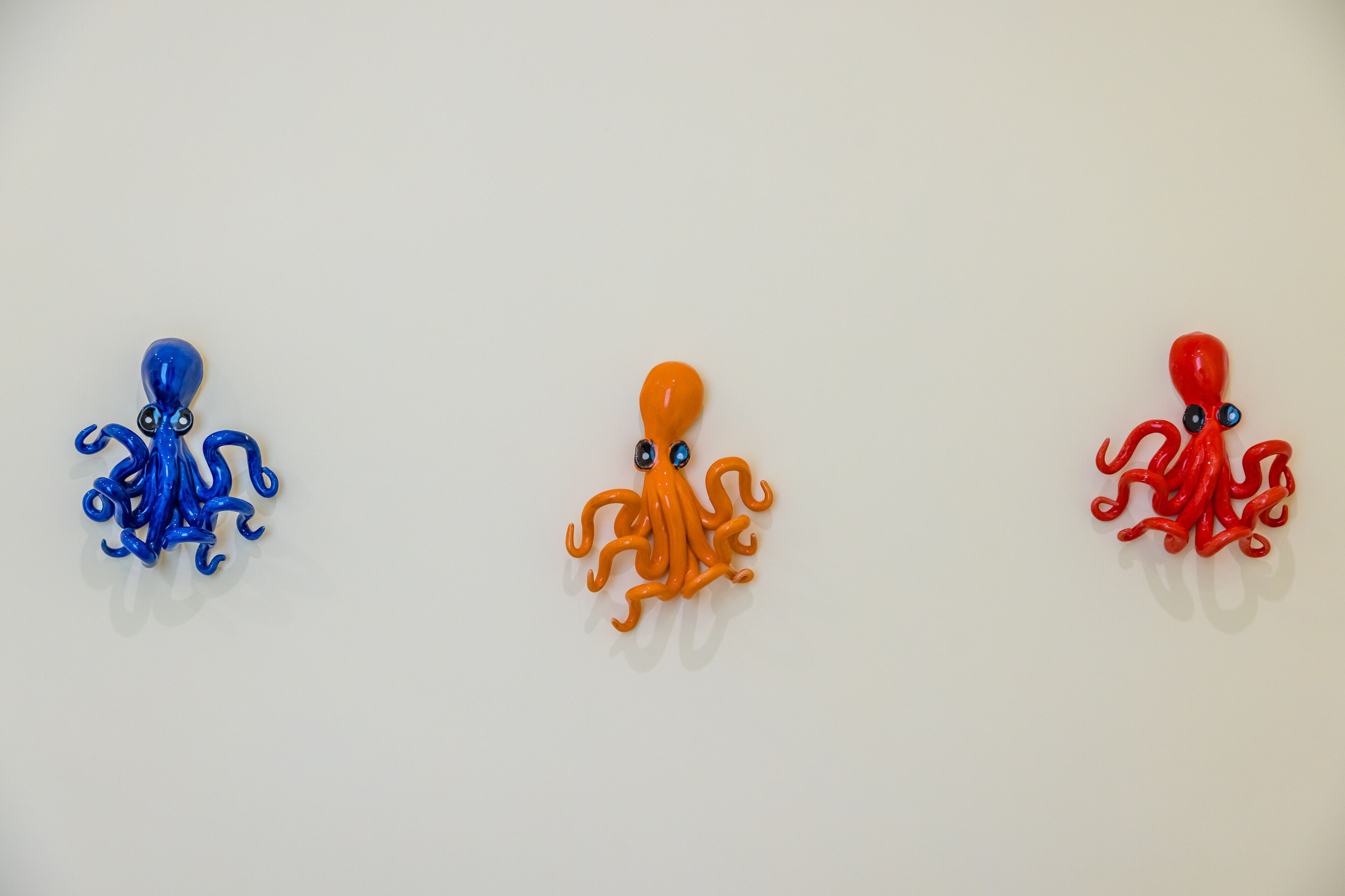 Three octopus-shaped objects in blue, orange, and red colors.