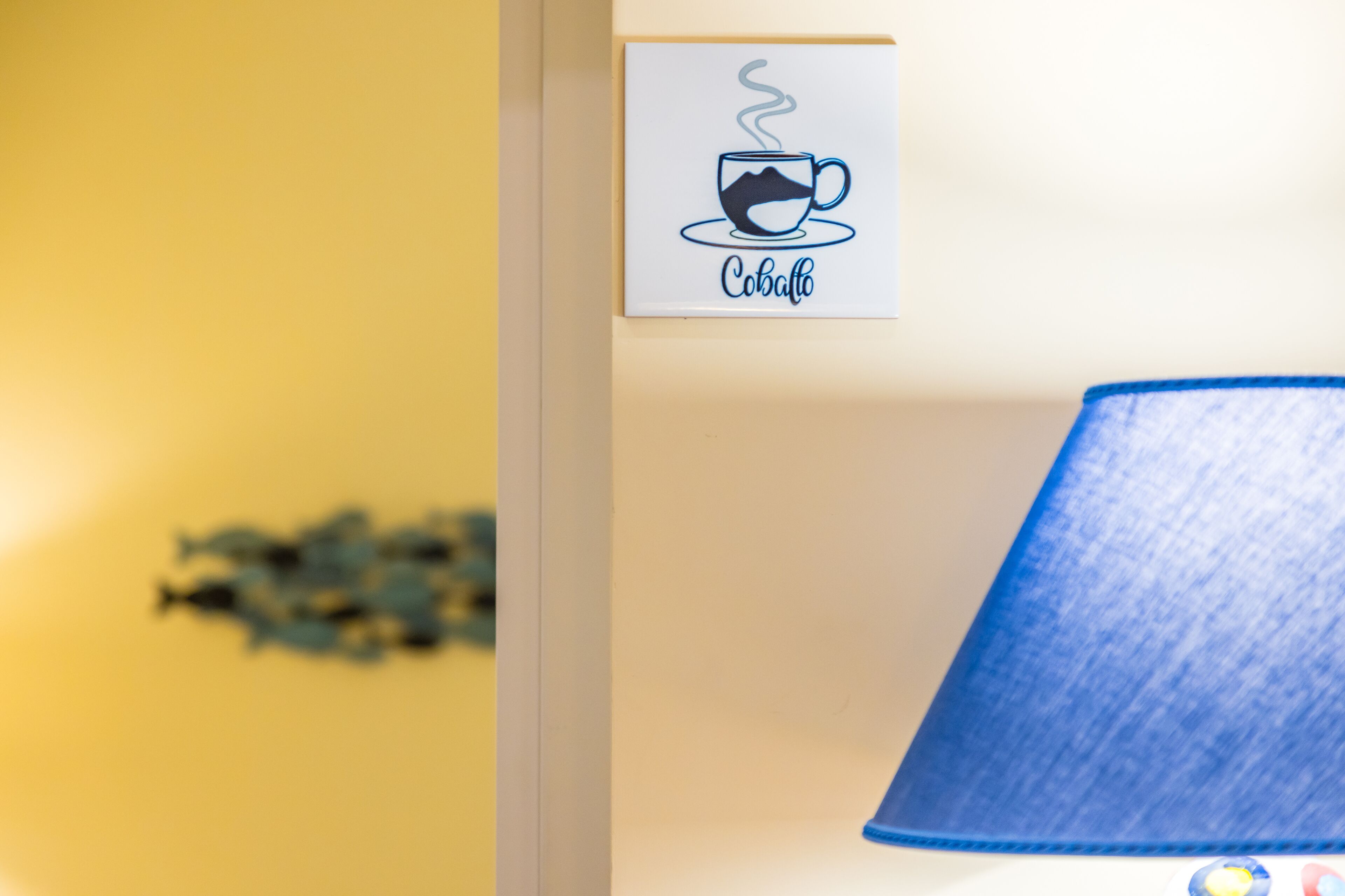 Eine Wand mit einem Schild, das eine Kaffeetasse und den Schriftzug 'Cobalt' zeigt.