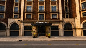 Un edificio con un letrero que dice 'VIRREYES' en la entrada, con amplias ventanas y una fachada simétrica.