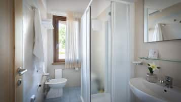 Un baño moderno con inodoro, bidé, ducha y lavamanos.
