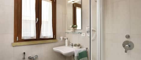 A bathroom with a toilet, sink, and shower.