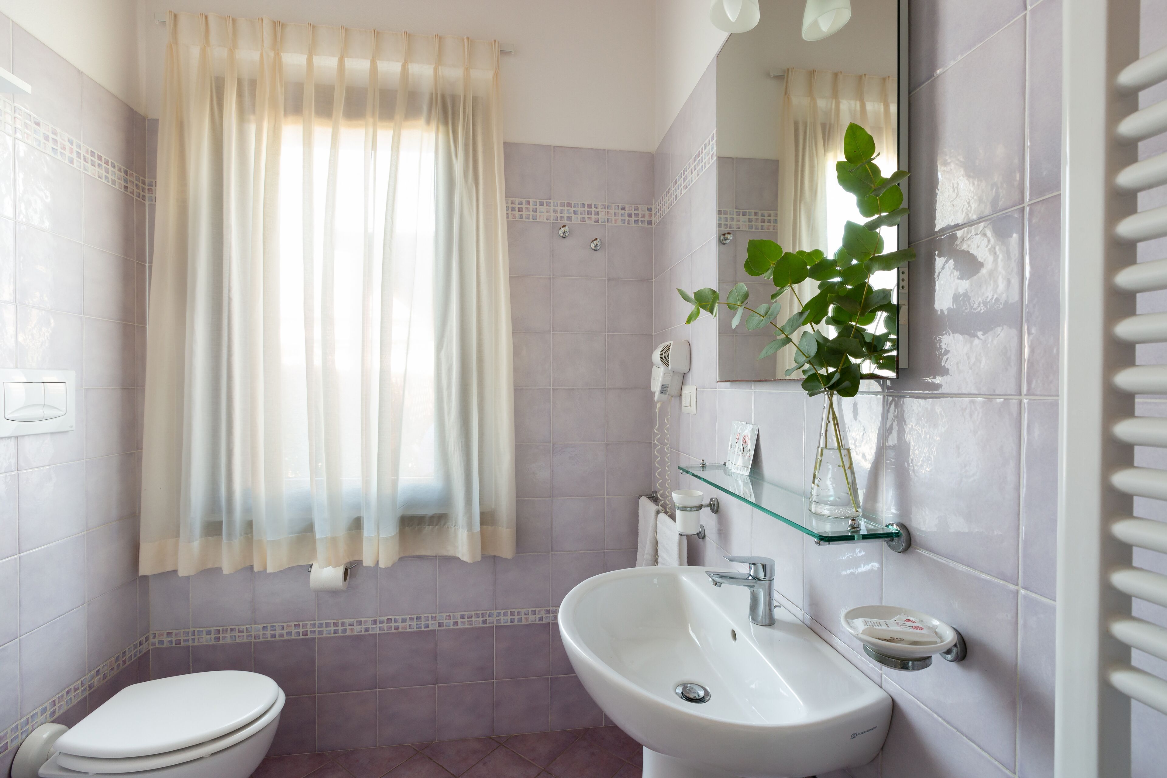 Un baño con inodoro, lavamanos y zona de ducha.