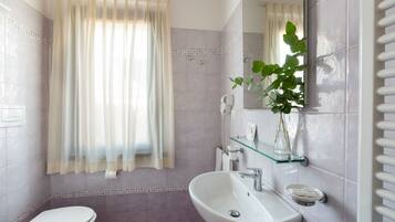 A bathroom with a toilet, sink, and shower area.