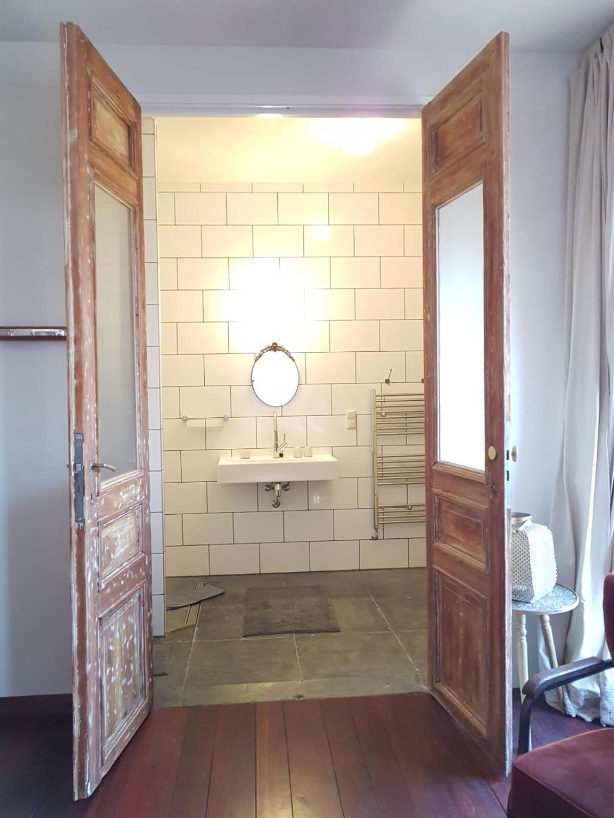 Ein Badezimmer mit einem weißen Waschbecken, einem Spiegel und einem Handtuchhalter.